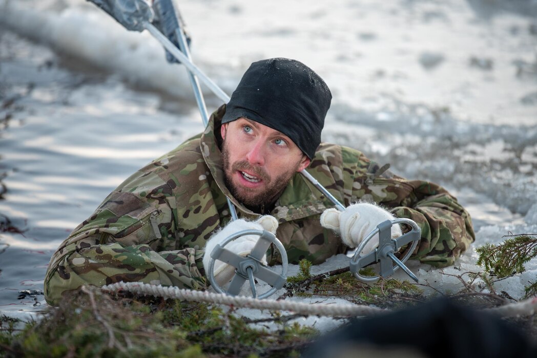 Senior Master Sergeant Sascha Kvale, a combat control flight chief in Kentucky Air National Guard’s 123rd Special Tactics Squadron, prepares to extricate himself from an “ice bath” in a frozen lake in Grubbnäsudden, Sweden, Jan. 14, 2022. Fifteen members from the 123rd STS — including combat controllers; pararescuemen; special reconnaissance personnel; search, evasion, resistance and escape troops; and support Airmen — came here to build upon their relationship with European partners during an arctic warfare training course. (U.S. Air National Guard photo by Phil Speck)