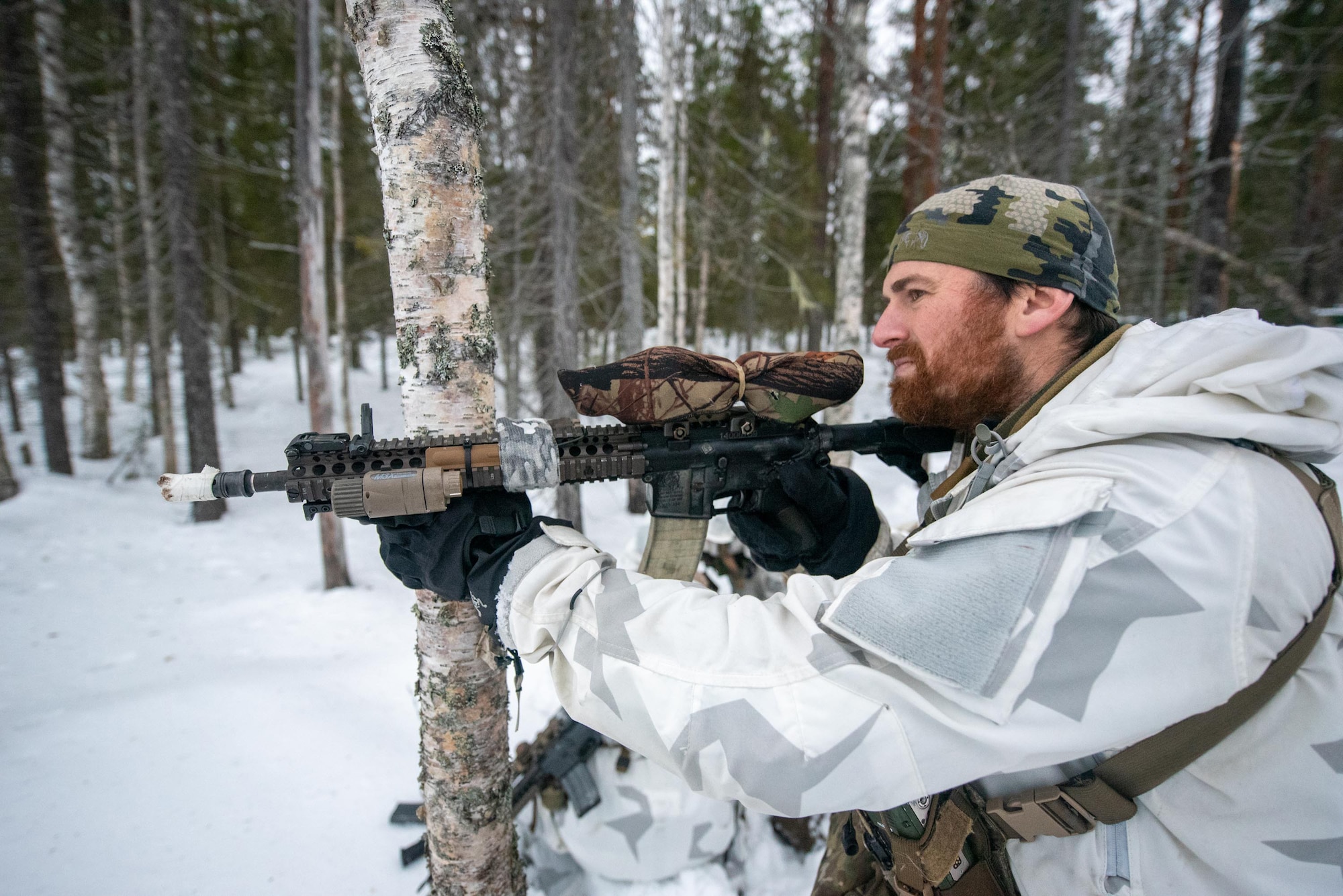 Master Sergeant Joshua Busch, a combat controller with the Kentucky Air National Guard’s 123rd Special Tactics Squadron, takes up a defensive fighting position in Grubbnäsudden, Sweden, Jan. 19, 2022. Fifteen members from the 123rd STS — including combat controllers; pararescuemen; special reconnaissance personnel; search, evasion, resistance and escape troops; and support Airmen — came here to build upon their relationship with European partners during an arctic warfare training course. (U.S. Air National Guard photo by Phil Speck)