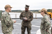U.S. Marine Corps Lt. Gen. Michael E. Langley (center), the commander of Fleet Marine Force, Atlantic, Marine Forces Command, Marine Forces Northern Command, speaks with U.S. Navy Rear. Adm. John V. Menoni (left), the commander of Expeditionary Strike Group 2 (ESG-2), and Cmdr. Elizabeth A Nelson, commanding officer of the Whidbey Island-class dock landing ship USS Gunston Hall (LSD 44), while touring the ship on March 25, 2022, prior to a regularly scheduled deployment. The USS Gunston Hall is one of the three Kearsarge Amphibious Ready Group dock landing ships scheduled to join 22nd Marine Expeditionary Unit who deployed earlier this month. (U.S. Marine Corps photo by Mr. Casey Price)