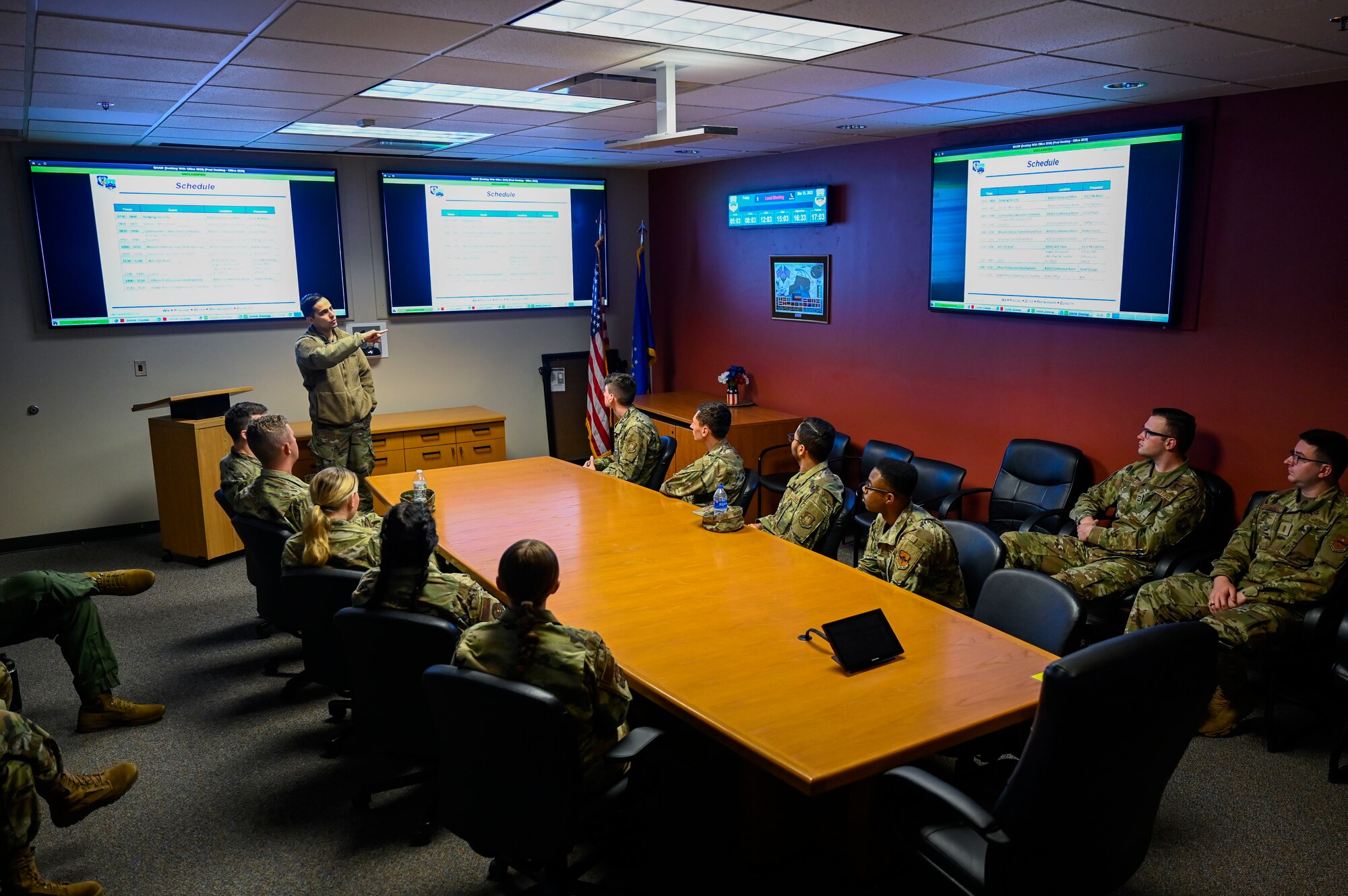 A photo of an airmen speaking at the head of a conference table