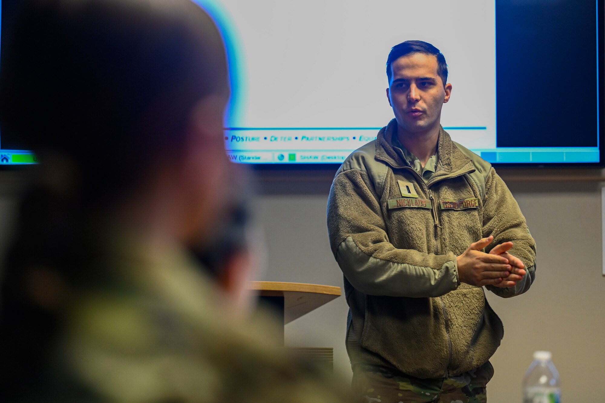 A photo of an airmen speaking in front of a group