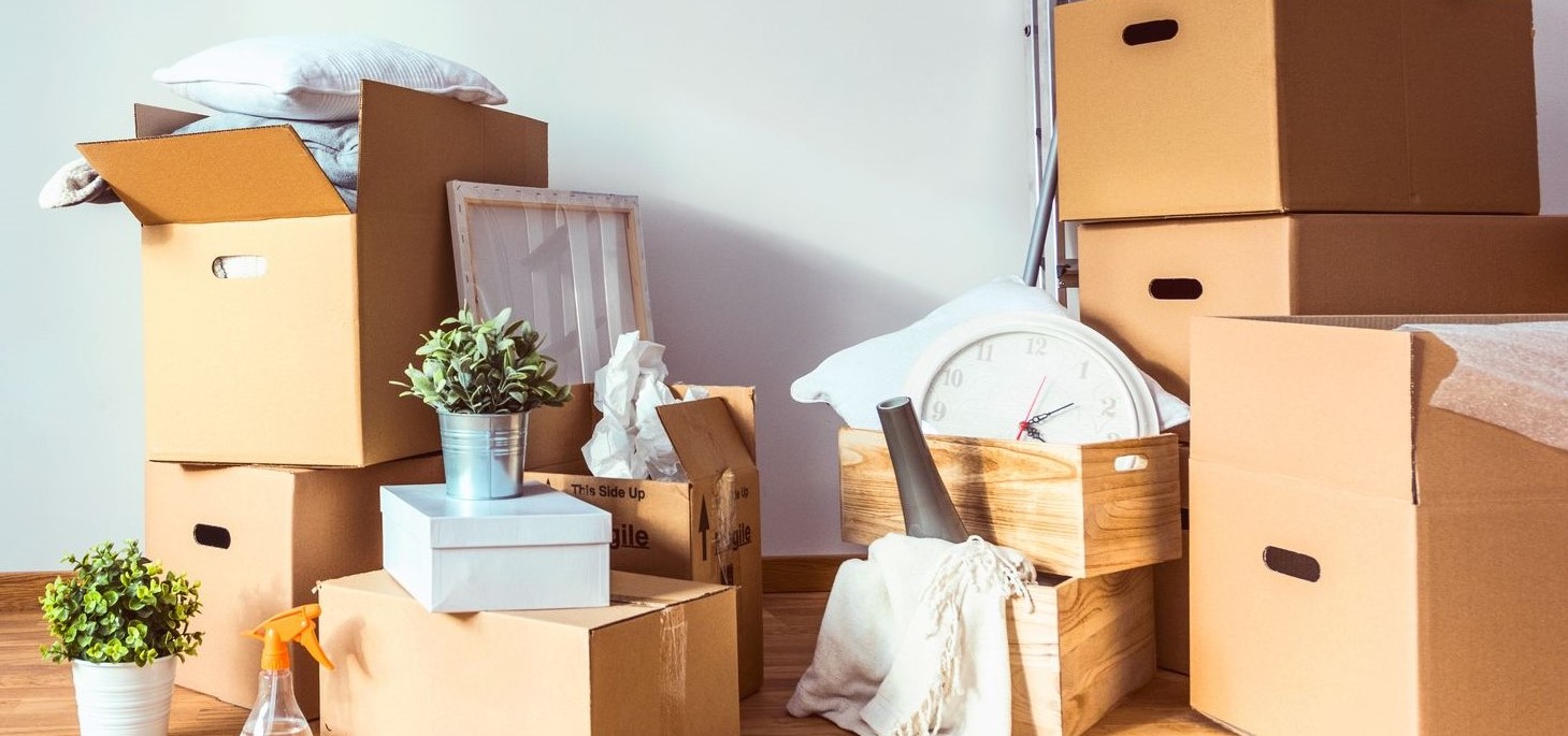 Cardboard moving boxes stacked with other household items.