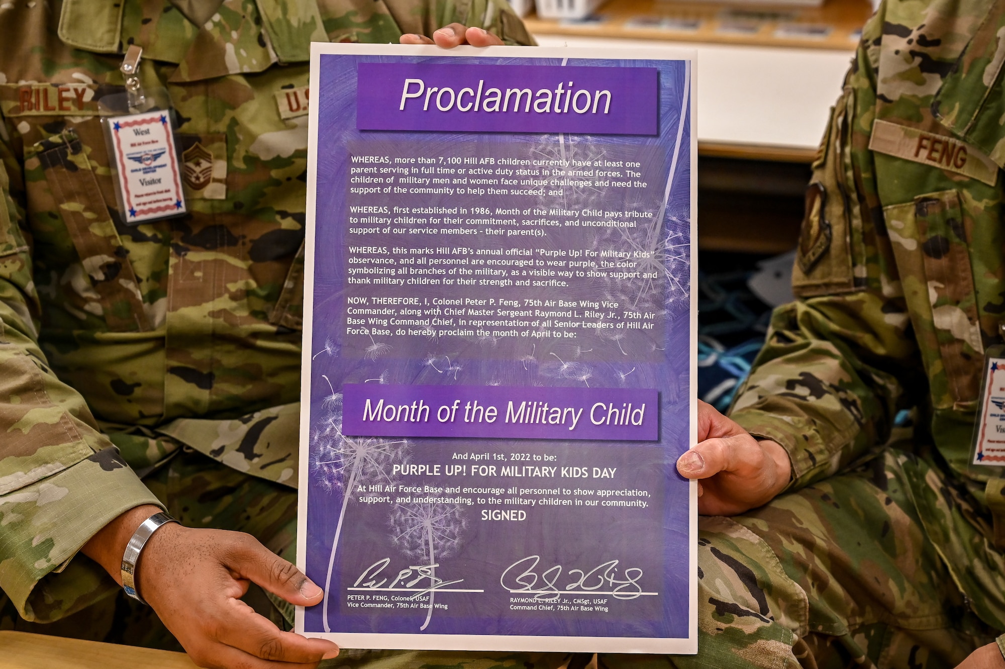 Chief Master Sgt. Raymond Riley, 75th Air Base Wing command chief (left) and Col. Peter Feng, 75th ABW vice commander, hold up the Month of the Military Child proclamation, March 29, 2022, at the Child Development Center on Hill Air Force Base, Utah.