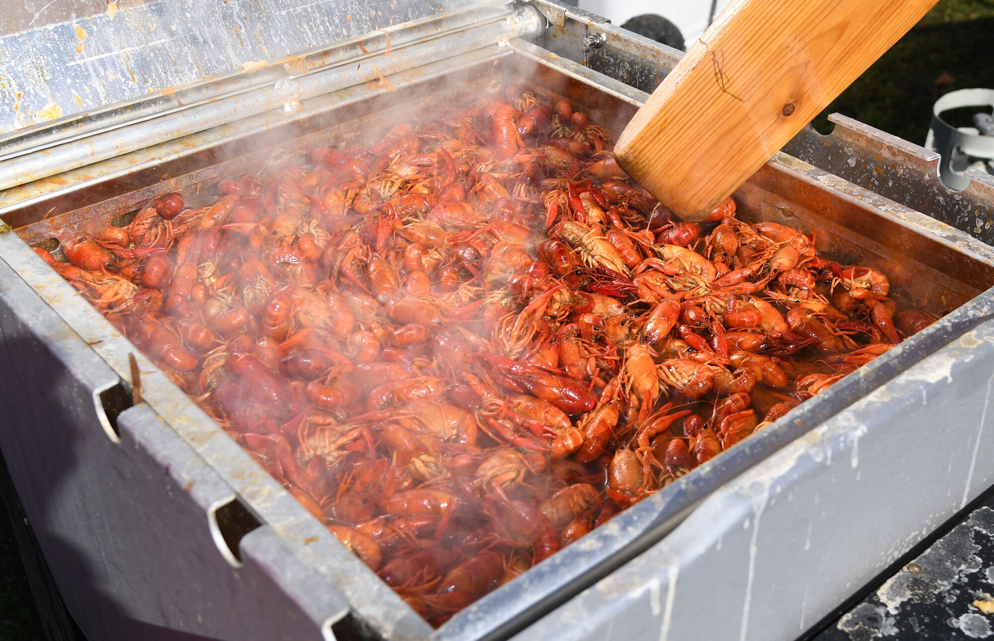 U.S. Air Force Retired Master Sgt. Tom McKrush, 335th Training Squadron instructor, and his team-mate, Edward Bagwell, stir their pot of boiled crawfish during the 10th Annual Crawfish Cook-Off at the Bay Breeze Event Center on Keesler Air Force Base, Mississippi, March 25, 2022. More than 20 teams competed in the event and more than 1,500 pounds of crawfish were distributed. (U.S. Air Force photo by Kemberly Groue)