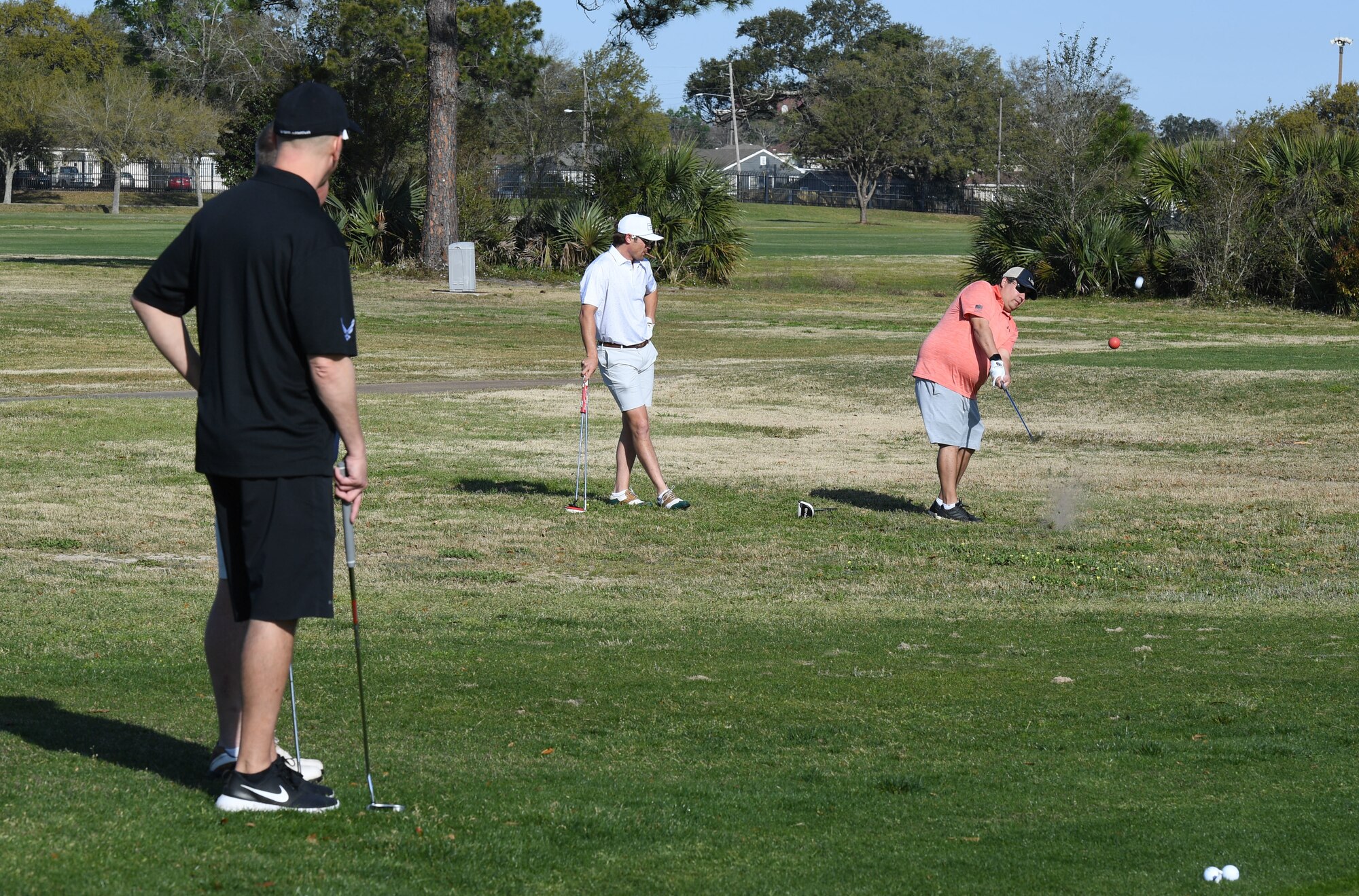 Eric Sievers, Bancorp South first vice president, hits a golf ball as U.S. Air Force Col. William Hunter, 81st Training Wing commander, and Cree Cantrell, former president of the Biloxi Bay Chamber of Commerce, watch during the Don Wylie Memorial Golf Tournament at the Bay Breeze Golf Course on Keesler Air Force Base, Mississippi, March 26, 2022. Keesler won the annual tournament against the Biloxi Bay Chamber of Commerce, which raised funds to help the Military & Veterans Affairs committee honor military members. (U.S. Air Force photo by Kemberly Groue)