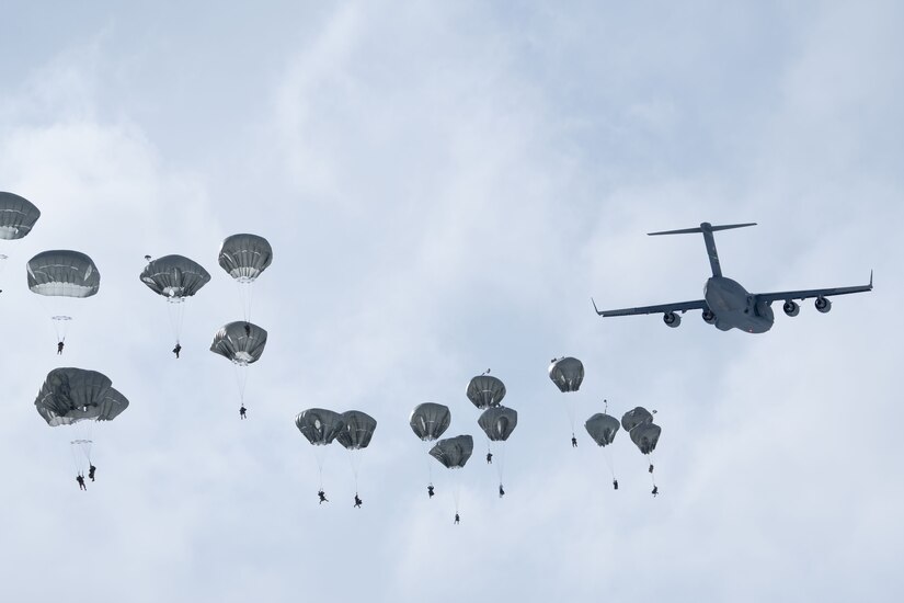 Photo of paratroopers descending after jumping out of a C-17