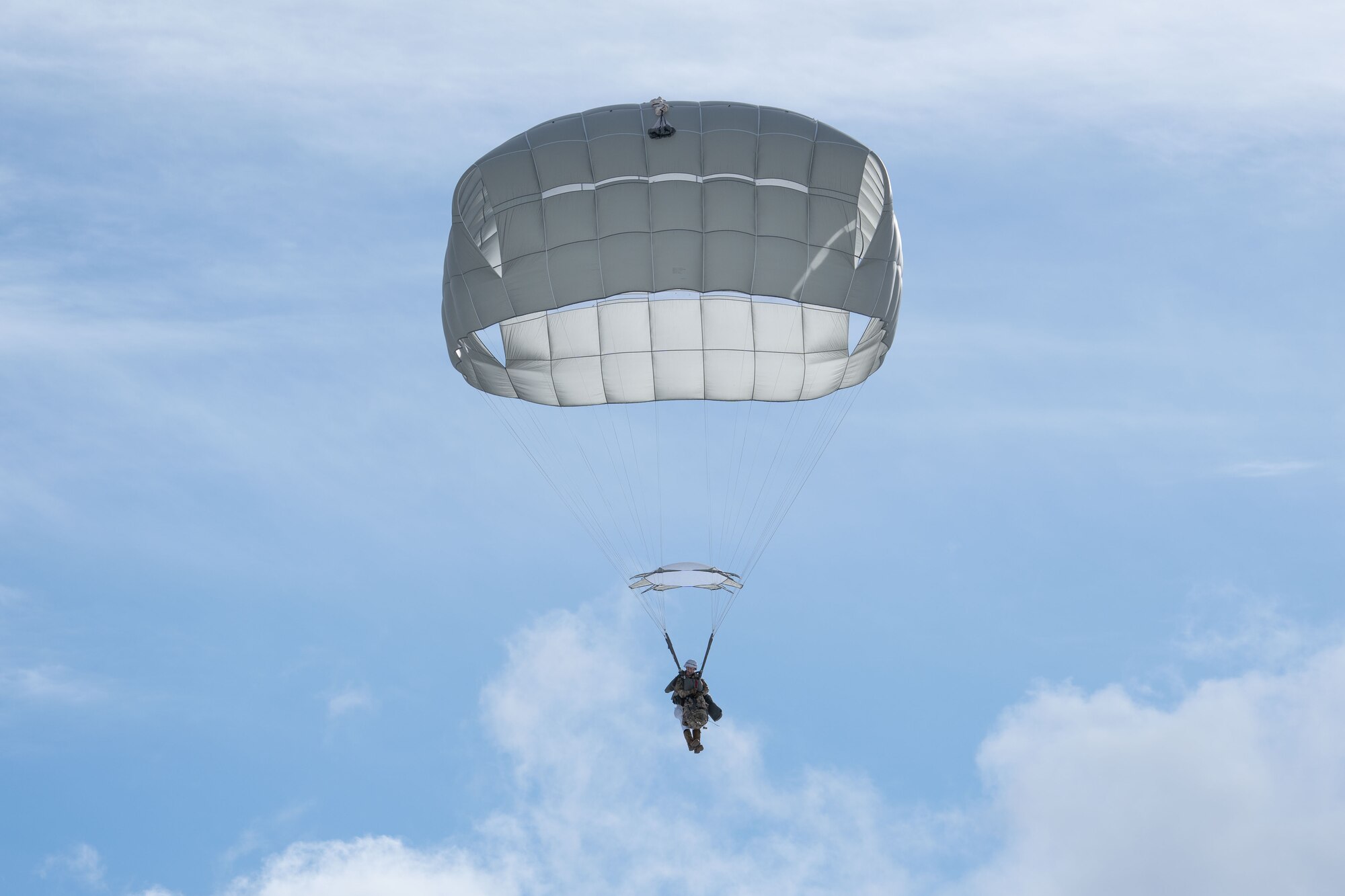 Photo of Army paratrooper descending after jumping out of a C-17