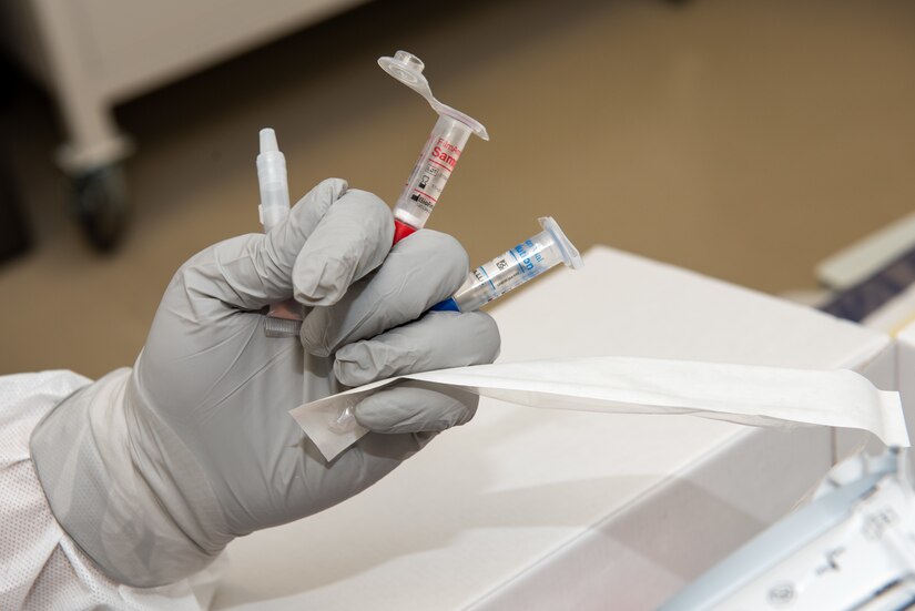 A photo of a lab technician holding COVID-19 testing equipment.