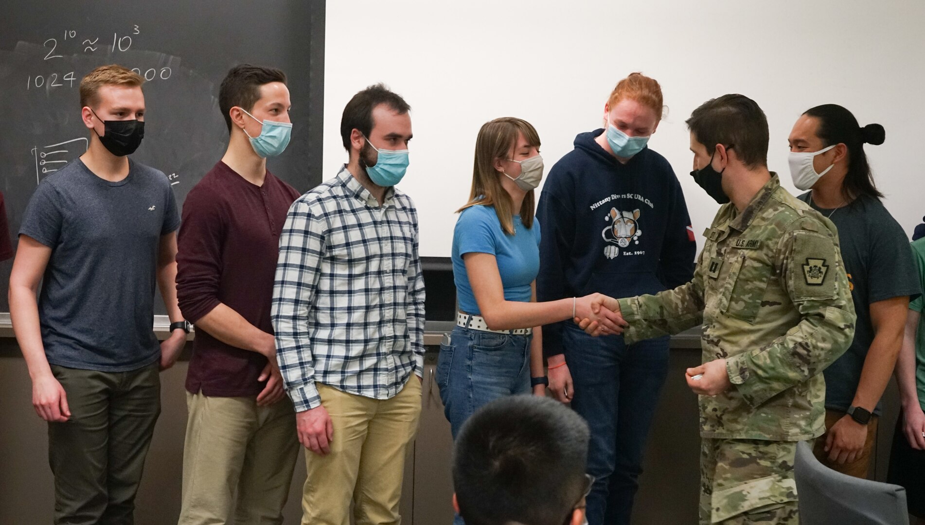 Capt. Sean Smith, right, deputy cyber chief for the Pennsylvania National Guard Defensive Cyber Operations Element team, and a Lebanon, Pa., native, presents an award to a Penn State University student for finishing in the top 10 during the PA National Guard Wi-Fighter Cyber Challenge at Penn State University on March 16, 2022. More than 40 students signed up to compete in a series of hacking and cyber security challenges.