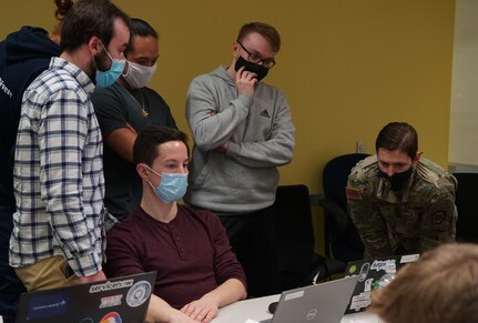 Capt. Sean Smith, right, deputy cyber chief for the Pennsylvania National Guard Defensive Cyber Operations Element team, and a Lebanon, Pa., native, works with several of the competitors during the PA National Guard Wi-Fighter Cyber Challenge at Penn State University on March 16, 2022. Smith and the other Soldiers from the DCOE worked to continuously develop the Wi-Fighter challenge to keep improving the skills of the communities that they support.