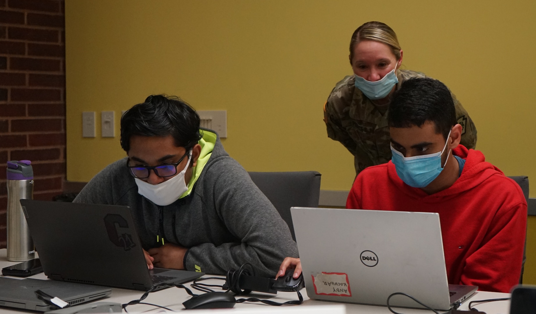 Maj. Christine Pierce, Defensive Cyber Operations Element Team Chief for the Pennsylvania Joint Force Headquarters, observes and assists Penn State students competing the PA National Guard Wi-Fighter event at Penn State University on March 16, 2022. More than 40 students competed in a series of hacking and cyber security challenges to win the competition.