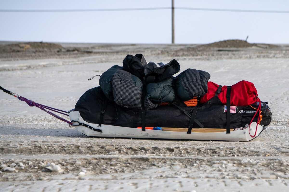 A sled of supplies is pulled across icy terrain.