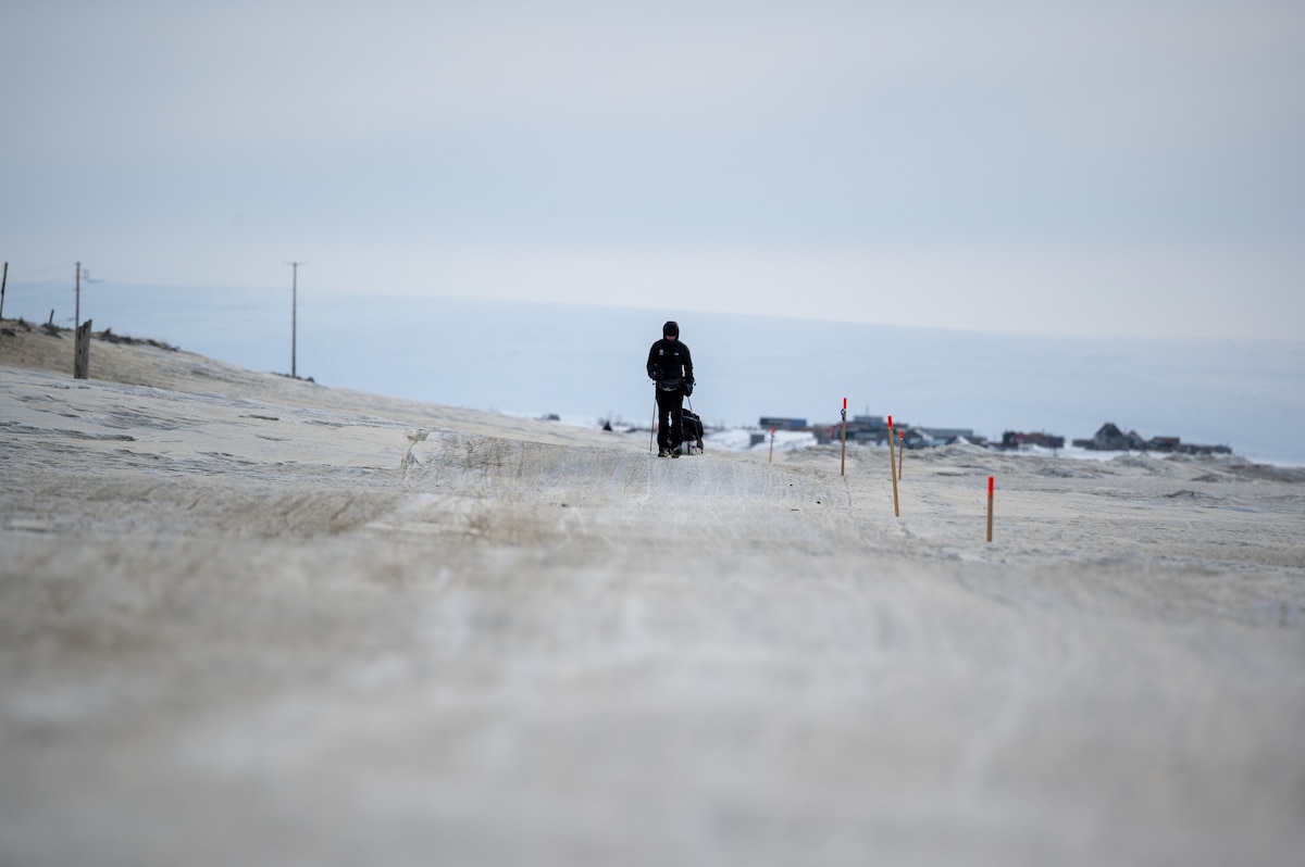 Maj. Joshua Brown hikes across icy terrain.