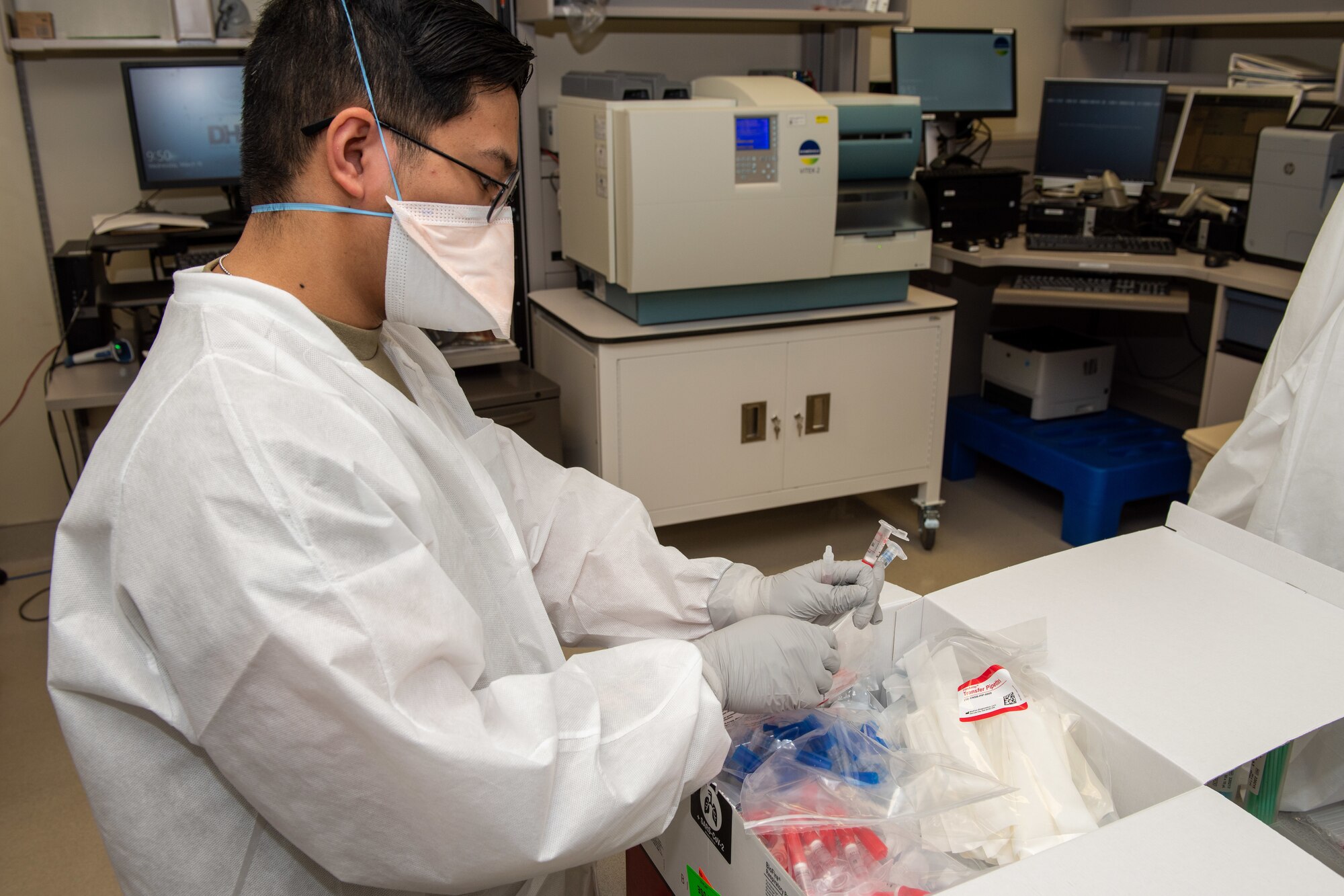 A photo of a lab technician preparing COVID-19 testing materials.