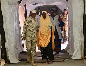 A Nigerien Armed Forces soldier escorts a woman to a doctor during a medical civic action program (MEDCAP) at Ouallam, Niger, March 16, 2022. The Niger-U.S. joint MEDCAP provides a critical piece of the U.S.’s whole-of-government approach which enables a secure, stable and prosperous Niger. (U.S. Air Force photo by Tech. Sgt. Stephanie Longoria)