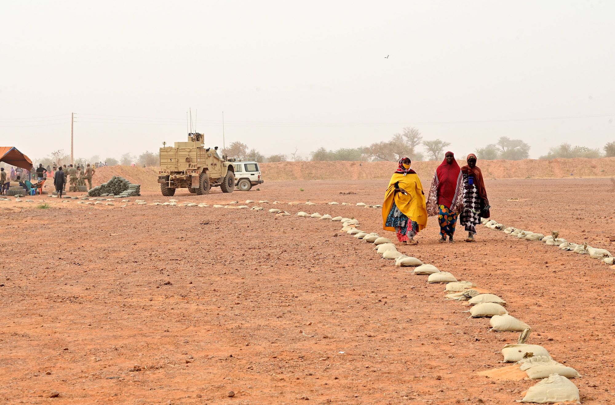 Three Nigerien women walk towards the medical tent during a medical civic action program (MEDCAP) in Ouallam, Niger, March 16, 2022. The Niger-U.S. joint MEDCAP provided medical treatment to approximately 550 patients, ranging from babies to the elderly. Engagements such as this increase cultural awareness, strengthen relationships and help U.S. service members understand problems local villagers face.  (U.S. Air Force photo by Tech. Sgt. Stephanie Longoria)
