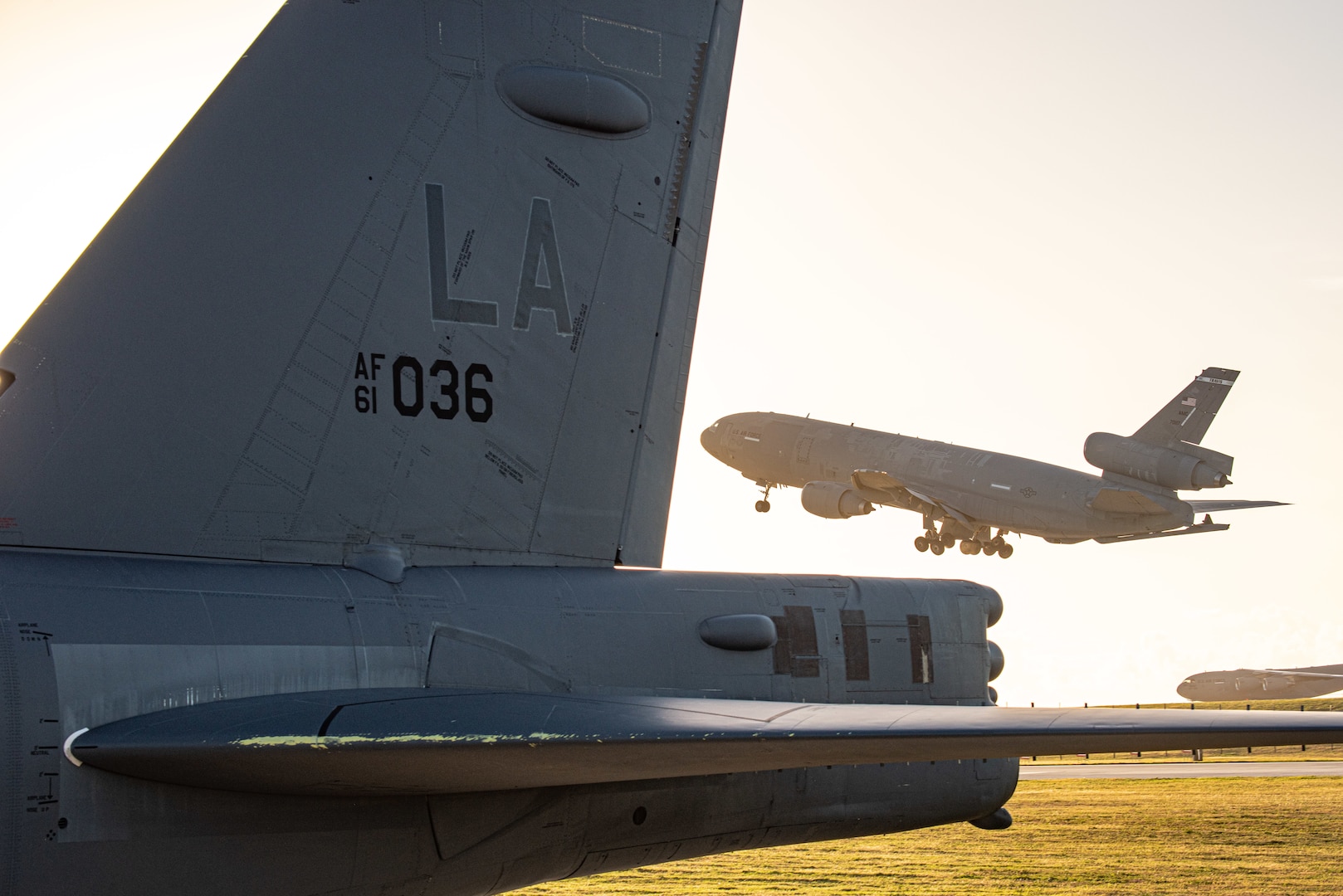 A KC-10 Extender from Travis Air Force Base, California, takes off in front of a B-52H Stratofortress at Andersen Air Force Base, Guam, Feb. 21, 2022. The B-52 aircrews will execute Bomber Task Force missions by integrating with partners and allies in support of a free and open Indo-Pacific region. (U.S. Air Force photo by Senior Airman Jonathan E. Ramos)