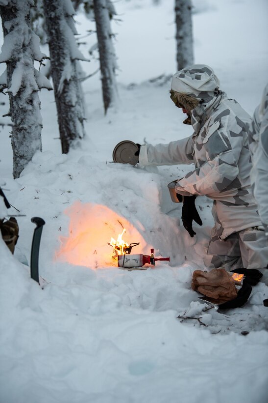 An Airman with the Kentucky Air National Guard’s 123rd Special Tactics Squadron melts snow with a field stove in Grubbnäsudden, Sweden, Jan. 11, 2022. Fifteen members from the 123rd STS — including combat controllers; pararescuemen; special reconnaissance personnel; search, evasion, resistance and escape troops; and support Airmen — came here to build upon their relationship with European partners during an arctic warfare training course. (U.S. Air National Guard photo by Phil Speck)