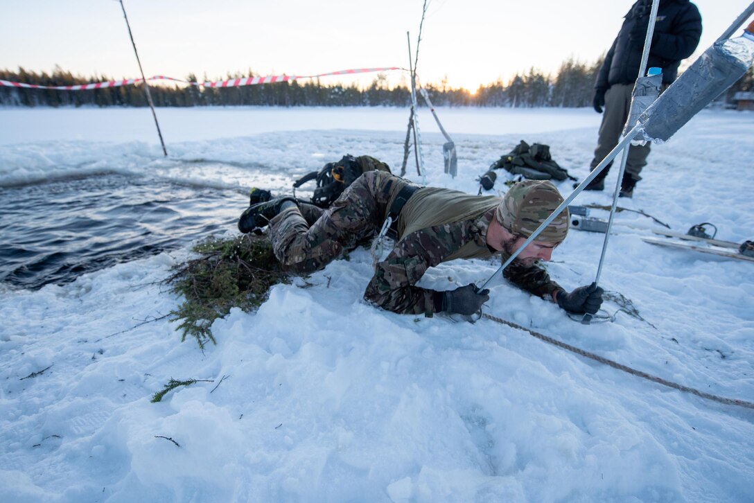 Tech. Sgt. Justin Kumor, a special reconnaissance specialist with the Kentucky Air National Guard’s 123rd Special Tactics Squadron, climbs out of an “ice bath” in Grubbnäsudden, Sweden, Jan. 14, 2022. Fifteen members from the 123rd STS — including combat controllers; pararescuemen; special reconnaissance personnel; search, evasion, resistance and escape troops; and support Airmen — came here to build upon their relationship with European partners during an arctic warfare training course. (U.S. Air National Guard photo by Phil Speck)