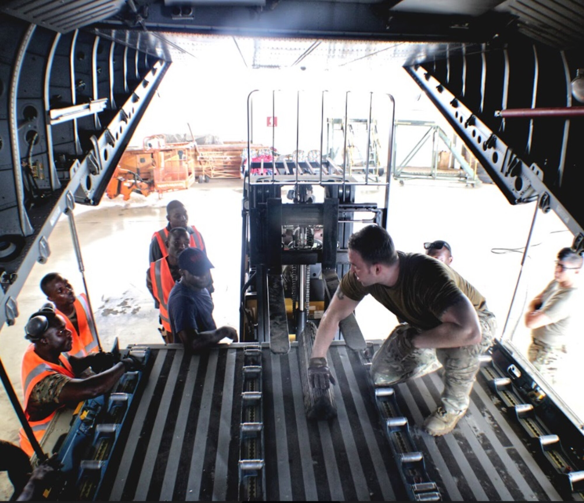 U.S. Air Force Staff Sgt. Derrek Webb, center, 818th Mobility Support Advisory Squadron air advisor, trains Ghanaian Armed Forces members on how to load cargo onto an Airbus C-295 using a forklift March 2, 2022, at Air Force Base Accra, Ghana. Air advisors deployed to Ghana in support of the U.S. Africa Command’s African Peacekeeping Rapid Response Partnership Training program to prepare Ghanaian forces for an upcoming U.N. deployment. (Courtesy photo)