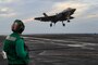 Aviation Boatswain's Mate (Equipment) 1st Class Mackenzie Poskevich, from Sioux City, Iowa, observes flight operations on the flight deck of the Nimitz-class aircraft carrier USS Abraham Lincoln (CVN 72).