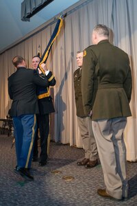 Command Sgt. Maj Richard Thalman passes the organizational colors to Brig. Gen. Tyler Smith during a change-of-command ceremony March 13, 2022 at Draper, Utah.