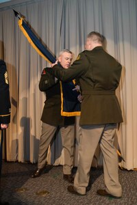 Maj. Gen Michael Turley, adjutant general, Utah National Guard, passes the organizational colors to Brig. Gen. Joseph Green during a change-of-command ceremony March 13, 2022 at Draper, Utah