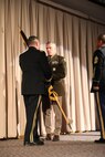 Brig. Gen. Tyler Smith passes the organizational colors to Maj. Gen Michael Turley, adjutant general, Utah National Guard, during a change-of-command ceremony March 13, 2022 at Draper, Utah