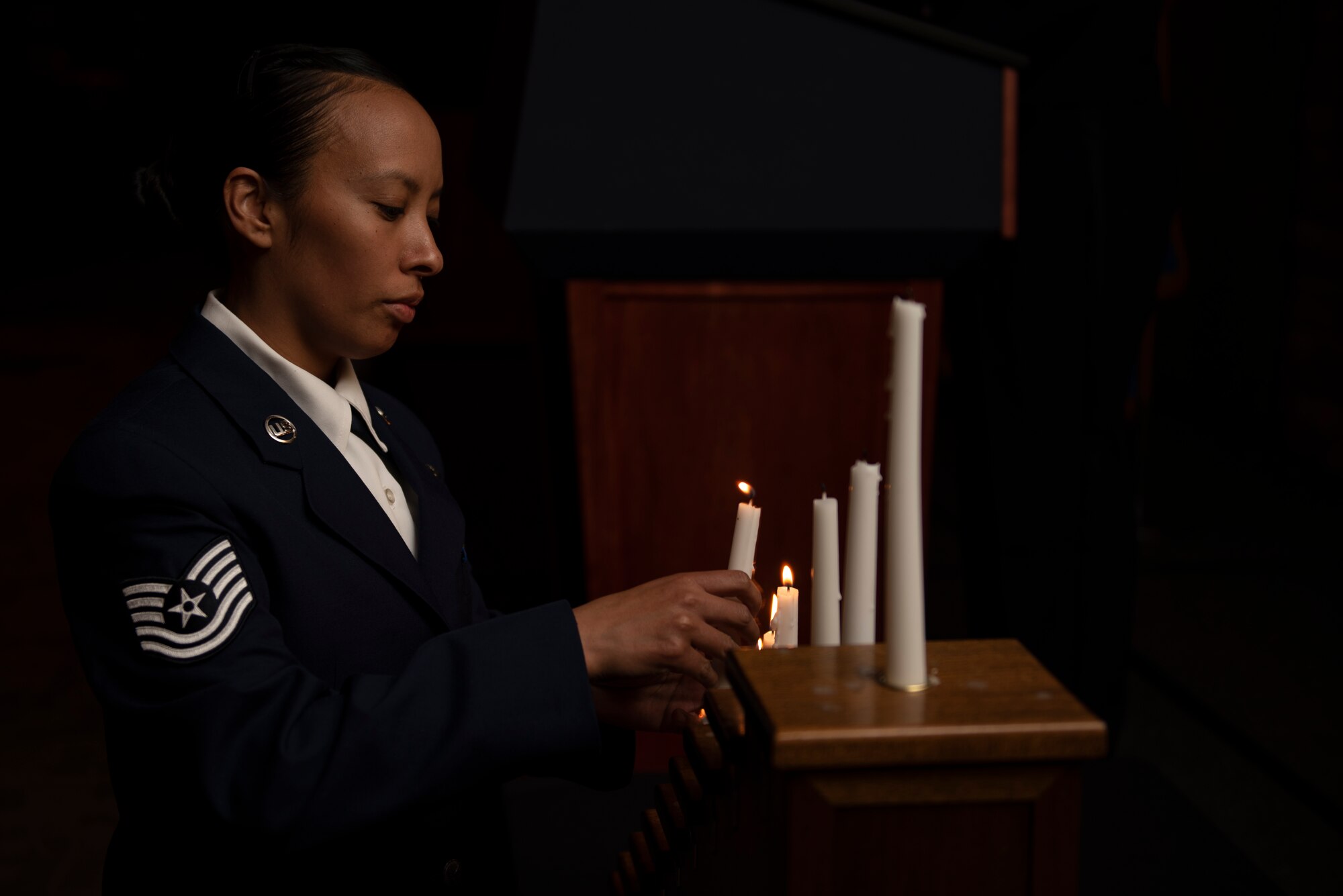 Tech Sgt. Michele Atencio, lights a candle during the Holloman Chief's Group Chief Recognition Ceremony, with each candle representing a rank in the enlisted force structure.