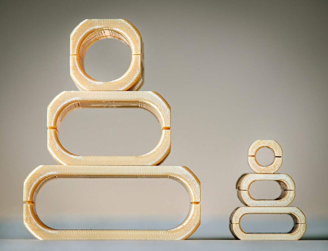 A close up view of the three sizes of thermoplastic blown optic fiber cable clamps designed by Brandon Rottle, nuclear general foreman, Shop 67, Marine Electronics. (U.S. Navy photos by Scott Hansen)