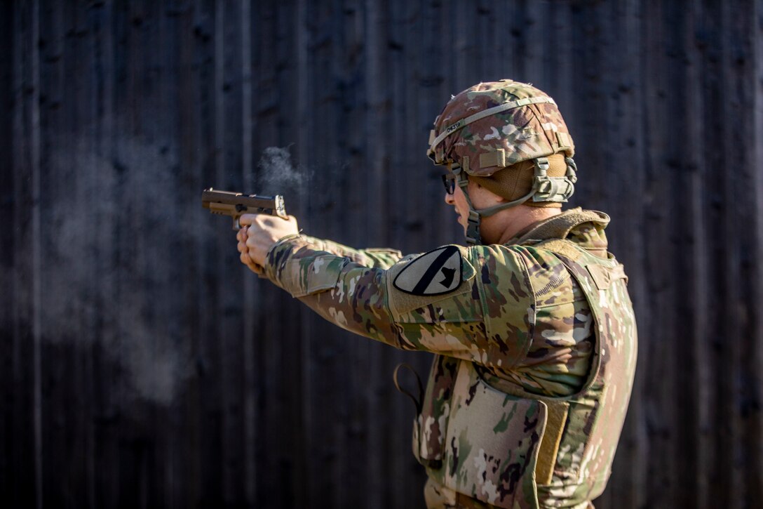A soldier shoots a pistol.