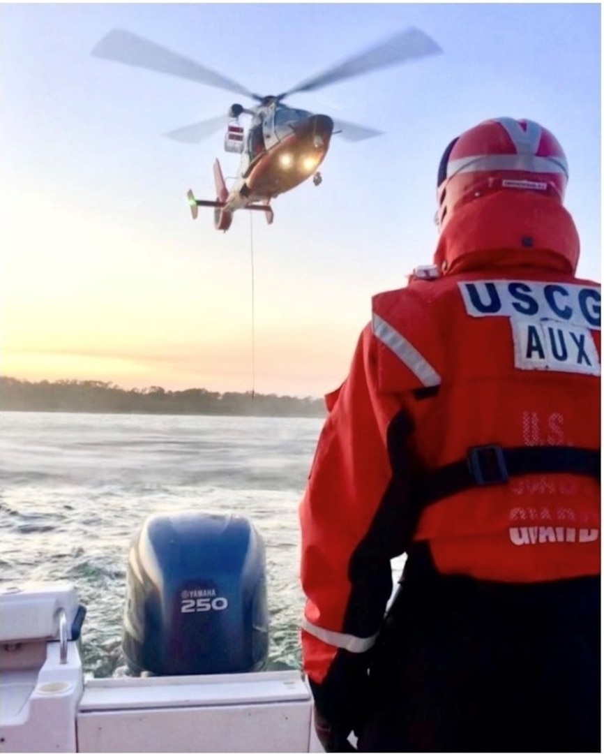 Auxiliarist Phil Deloach keeps a watchful eye on an incoming U.S. Coast Guard MH-65 Dolphin helicopter. In this drill, the helicopter dropped a rescue basket on the Auxiliary vessel’s deck. Photo by Coast Guard Auxilliarist Andrew Niquette.