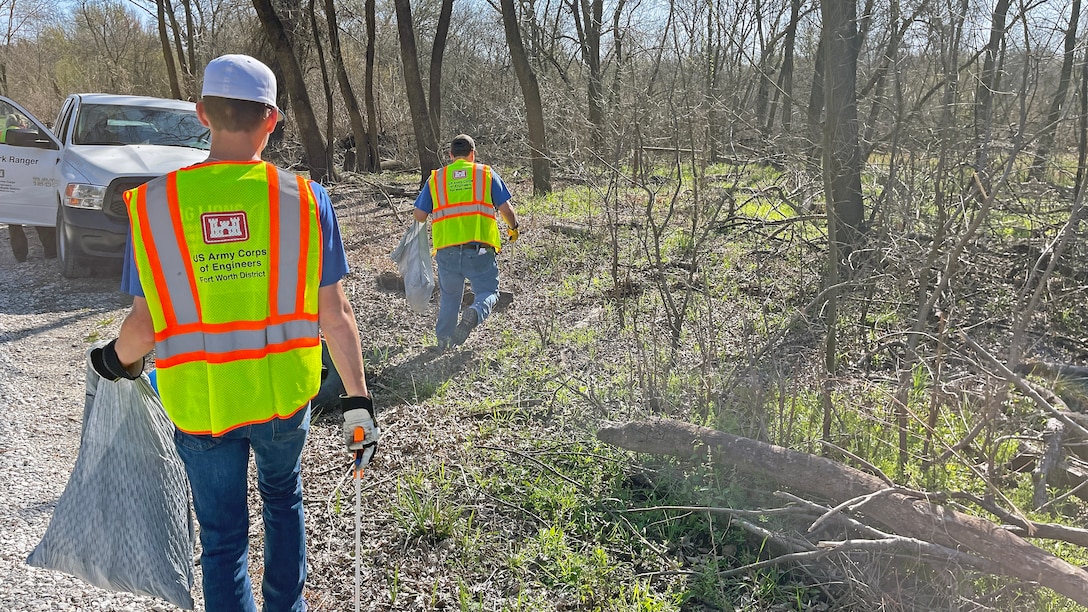 Person picks up trash in woods