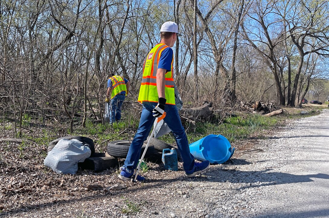 Person picks up trash in woods