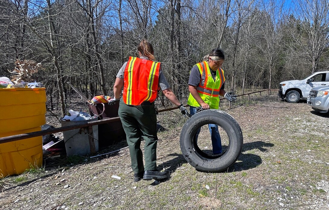 Person picks up trash in woods