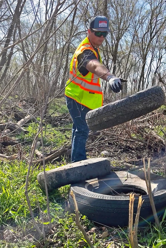 Person picks up trash in woods