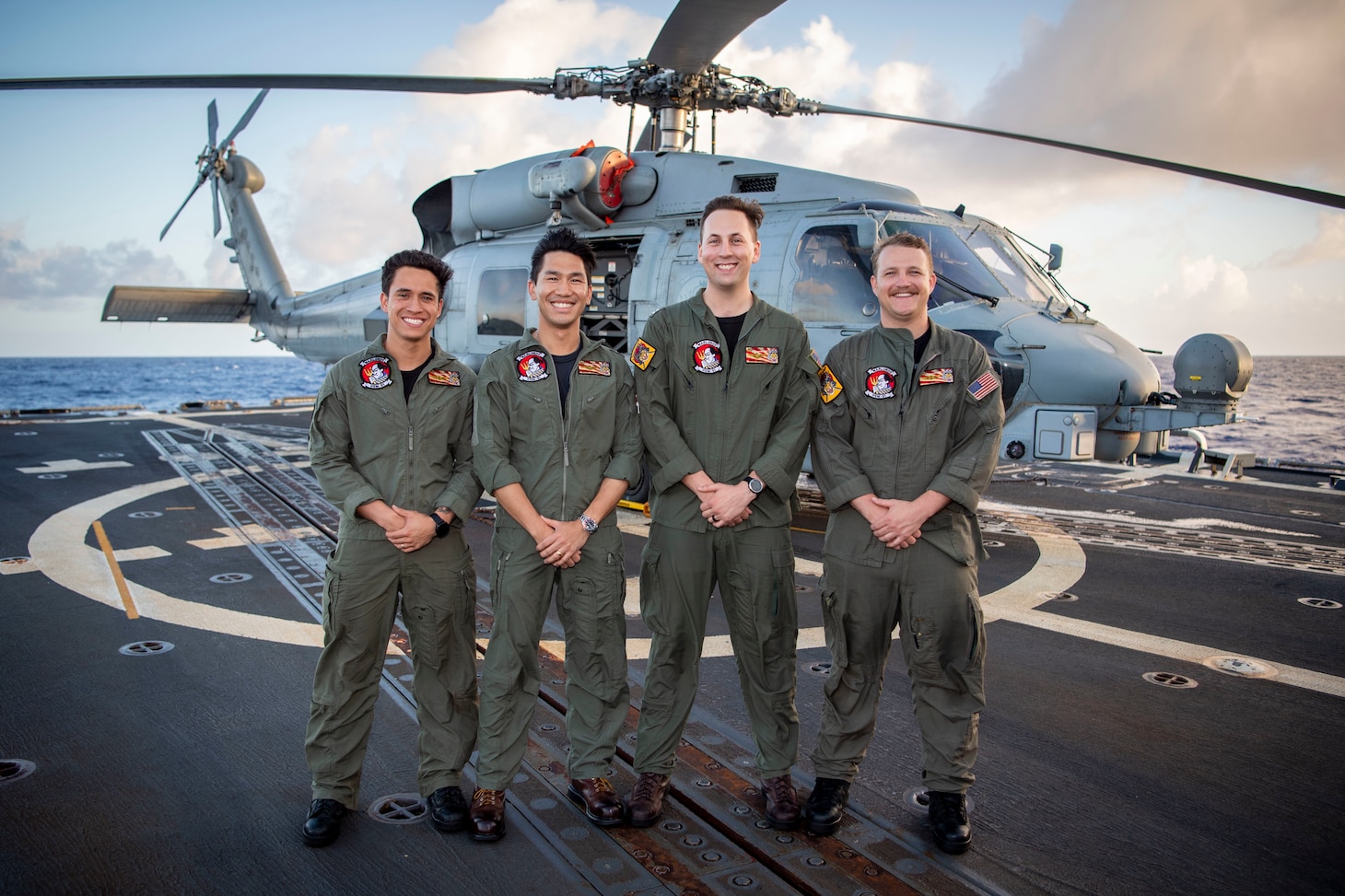 PHILIPPINE SEA (March 27, 2022) Naval Air Crewman (Helicopter) 2nd Class Kaimana Rodriguez, left, from San Dimas, California, Lt. Quoc Duong, from King George, Virginia, Lt. Kristopher Appel, from Knoxville, Tennessee, and Naval Air Crewman (Helicopter) 2nd Class Baldwin Switzer, from Ocala, Florida, assigned to the “Warlords” of Helicopter Maritime Strike Squadron (HSM) 51 Detachment 3, pose for a photo in front of a MH-60R helicopter to celebrate a successful search and rescue operation, March 26, off the coast of Guam. HSM-51 Detachment 3, attached to the Arleigh Burke-class guided-missile destroyer USS Dewey (DDG 105), is conducting routine operations in the U.S. 7th Fleet area of responsibility in support of a free and open Indo-Pacific. (U.S. Navy photo by Mass Communication Specialist 1st Class Benjamin Lewis)
