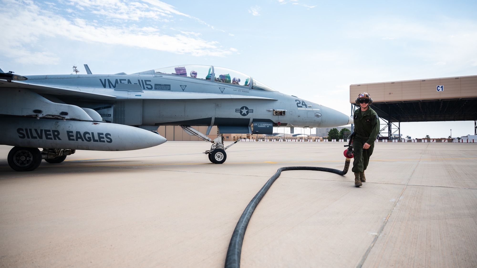 A U.S. Marine from the Marine Fighter Attack Squadron 115 carries a fuel hose after hot-pit refueling an F/A-18 Hornet at Prince Sultan Air Base, Kingdom of Saudi Arabia, Jan. 11, 2022. The VMFA-115 arrived at PSAB in late December, 2021, bringing a squadron of F/A-18s and support personnel to fully integrate into daily operations. (U.S. Air Force photo by Senior Airman Jacob B. Wrightsman)