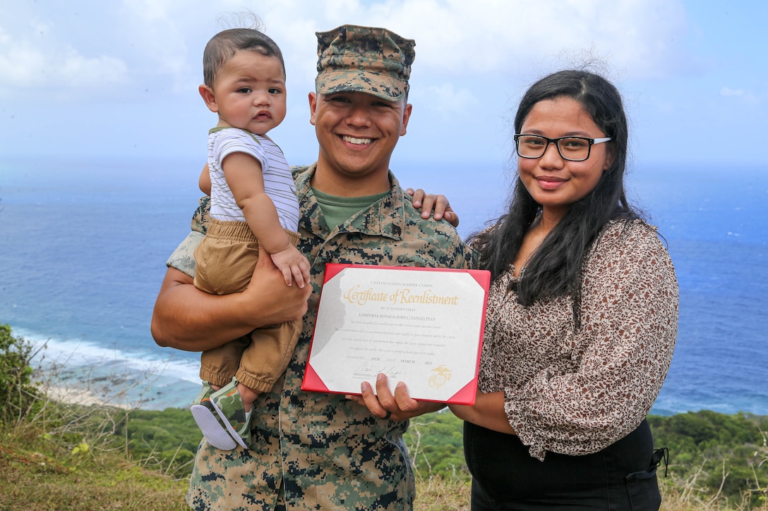U.S. Marine Corps Cpl. Donald Pangelinan, training non-commissioned officer for Marine Corps Base Camp Blaz, poses for a photo with his wife Tatiana and son while after his reenlistment ceremony at the Tarague Overlook on Andersen Air Force Base, Guam, March 29, 2022. Corporal Pangelinan’s hometown is Tanapag, Saipan, and he is a graduate from Marianas High School. (U.S. Marine Corps photo by Gunnery Sgt. Rubin J. Tan)