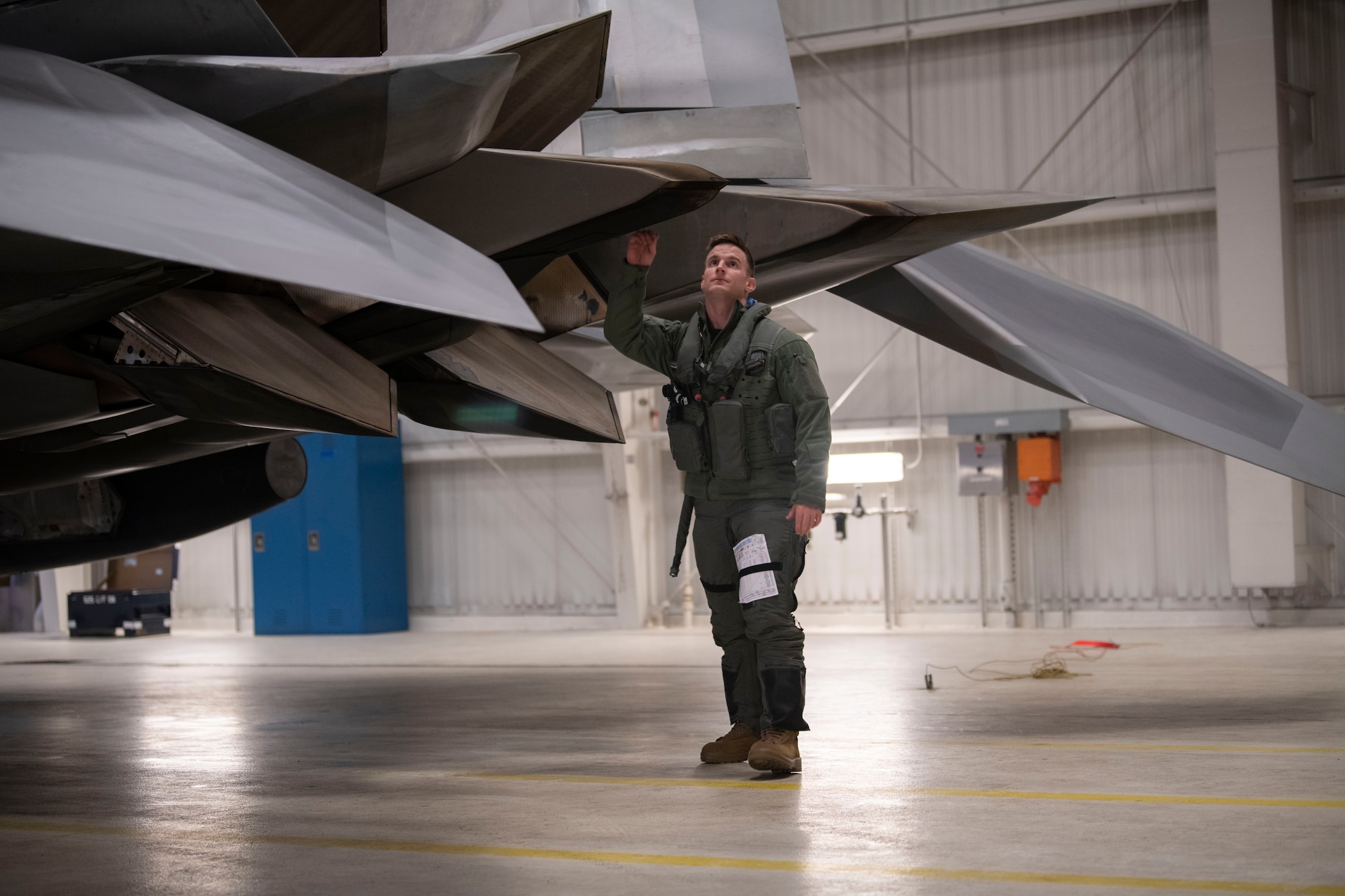 A pilot touches the F-22 aircraft tail