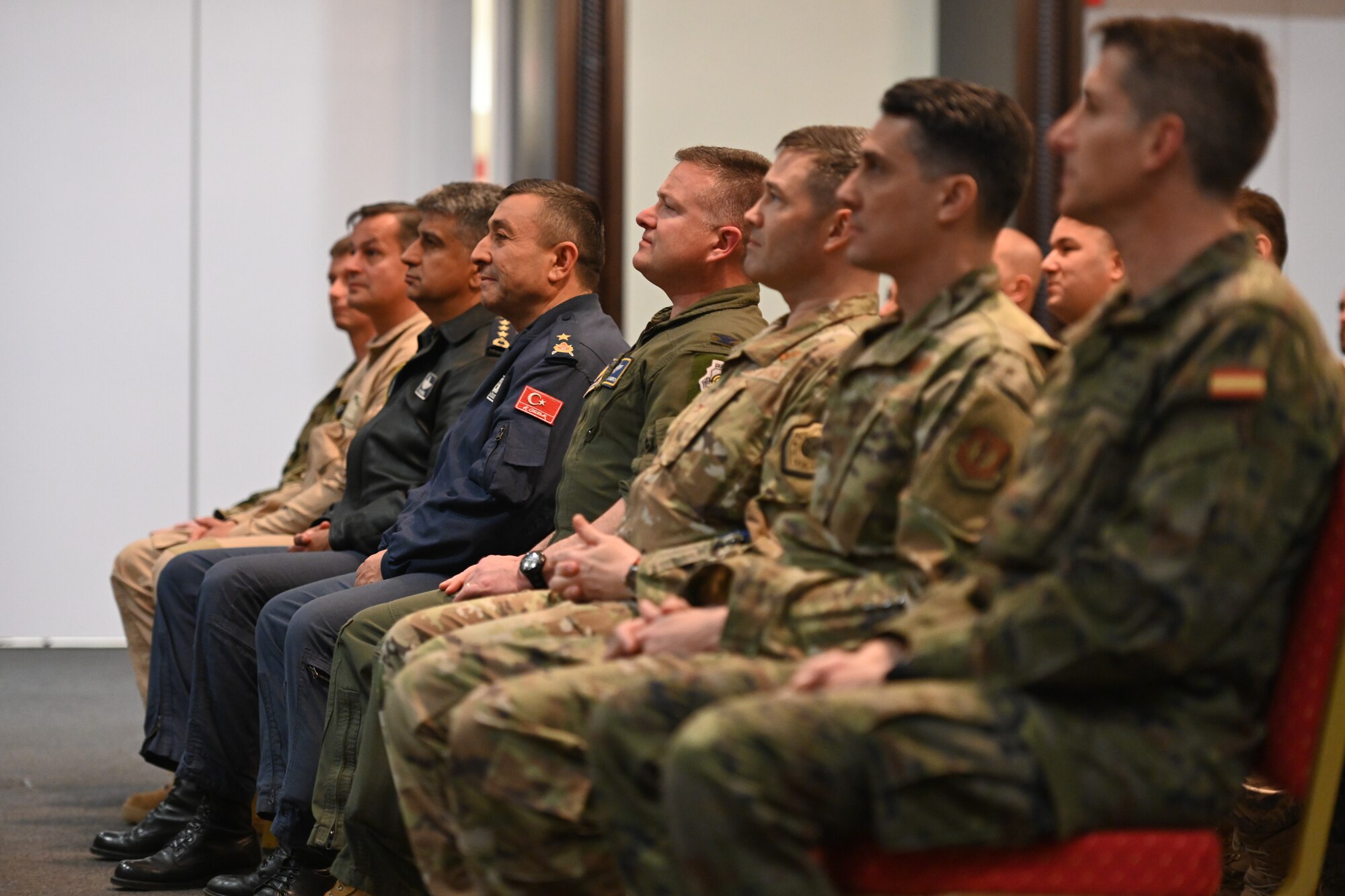 Military members sit and watch performance.