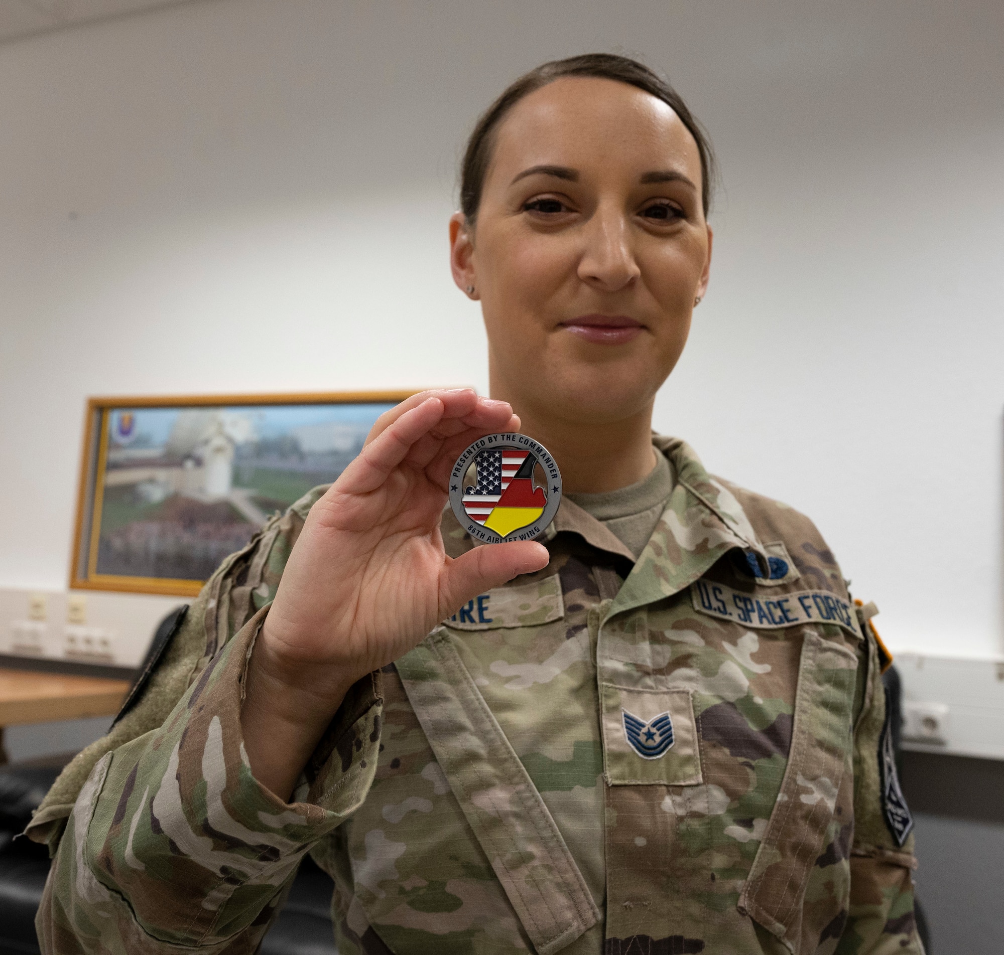 U.S. Space Force Tech. Sgt. Hollie Baire, 86th Communications Squadron non-commissioned officer in charge of the Technical Control Facility holds a coin at Ramstein Air Base, Germany, March 30, 2022. Baire was awarded the title of Airlifter of the Week because of her hard work, dedication and use of innovative ideas to increase efficiency across the 86th Communications Squadron. (U.S. Air Force photo by Senior Airman Thomas Karol)