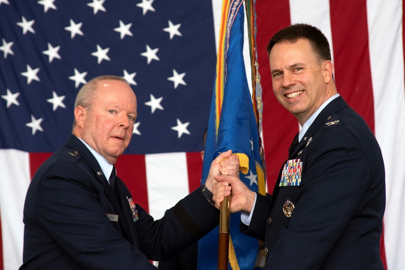 Brig. Gen. Michael Regan, left, commander of the Pennsylvania Air National Guard, passes the unit colors to 111th Attack Wing commander Col. Deane E. Thomey, during an assumption of command ceremony June 13, 2021, at Biddle Air National Guard Base in Horsham, Pa.