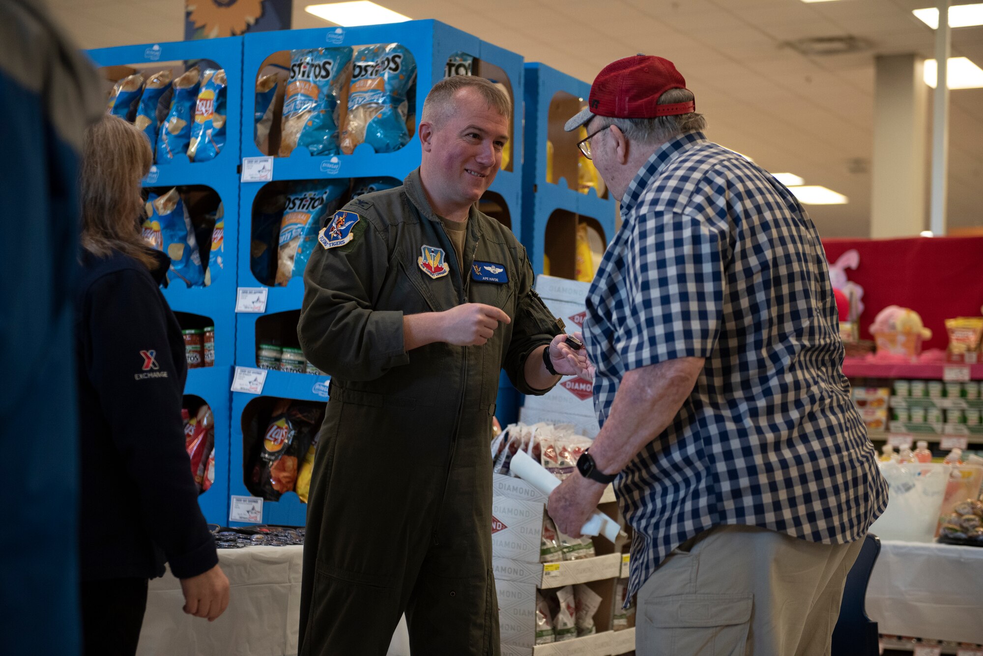 A photo of a man handing another man a lapel pin.