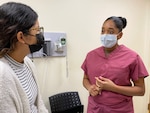 Midwife speaks with patient in exam room