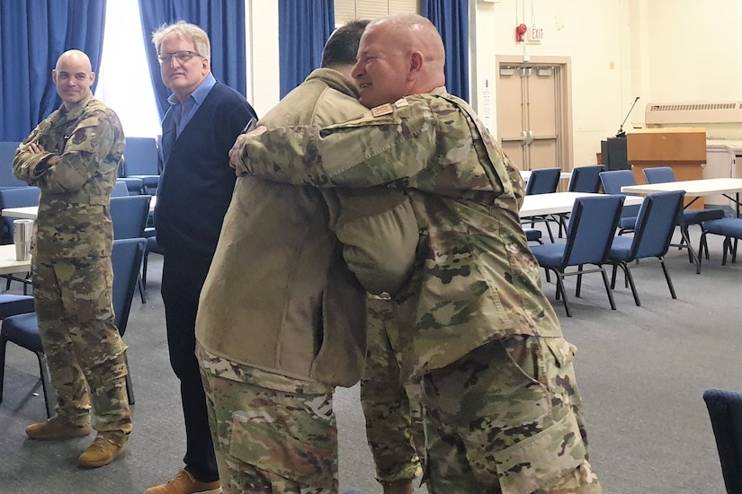Col. Deane E. Thomey, 111th Attack Wing Commander, receives a hug from Senior Master Sgt. Brian E. Zarilla (right), 111th Mission Support Group Senior Enlisted Leader, at Biddle Air National Guard Base, March 30, 2022, upon his return to duty after a more than 5-month absence. Thomey was recovering from injuries received in a plane crash in October 2021.