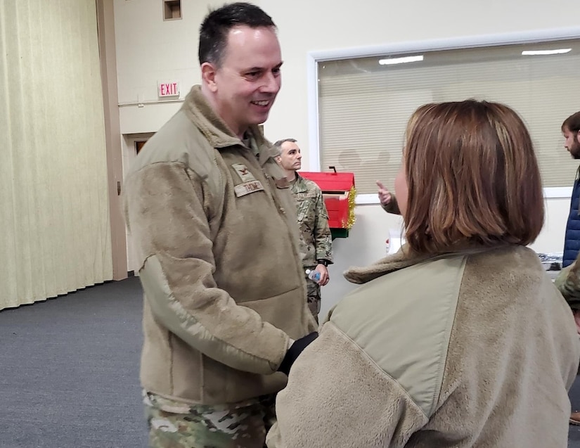 Col. Deane E. Thomey (left), 111th Attack Wing Commander, is greeted by Senior Master Sgt. Holly E. Schlittler, 111th Attack Wing Inspector General Superintendent, at Biddle Air National Guard Base, March 30, 2022, upon his return to duty after a more than 5-month absence. Thomey was recovering from injuries received in a plane crash in October 2021.