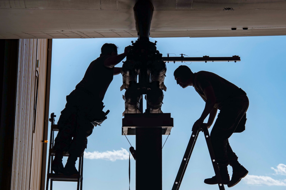 Airmen load missiles onto an aircraft during a competition.