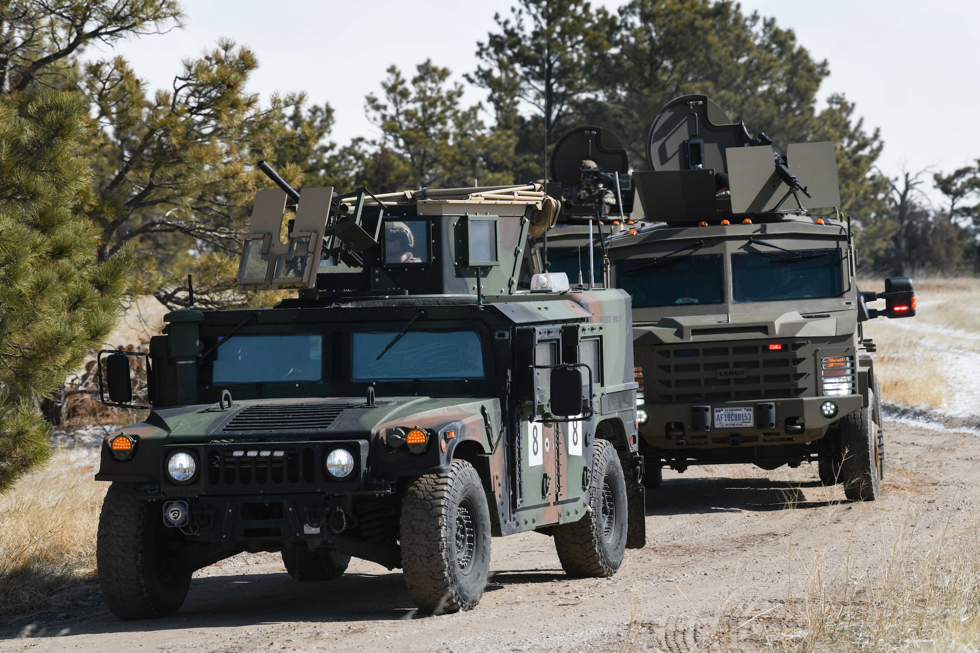 A convoy approaches a treeline moments before a simulated payload transporter attack in Pine Bluffs, Wyoming, March 30, 2022. The 90th Security Forces Group conducted full mission profile training to further develop response capabilities to contingency situations during a PT movement. (U.S. Air Force photo by Airman 1st Class Charles Munoz)