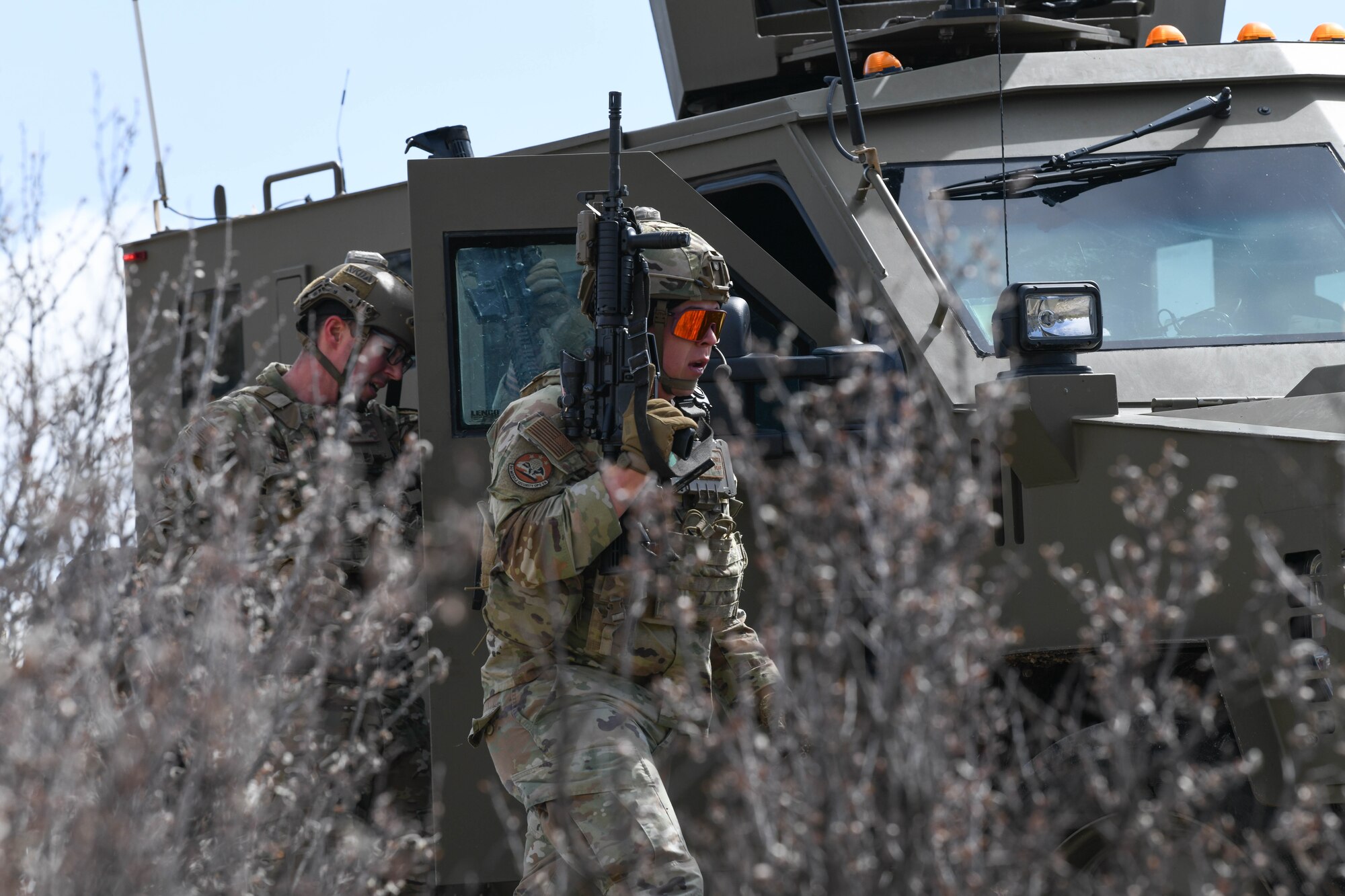 Airman 1st Class George Zapata, convoy response force leader at the 90th Missile Security Operations Squadron, sweeps a tree line for adversaries after a simulated payload transporter attack in Pine Bluffs, Wyoming, March 30, 2022. The 90th Security Forces Group conducted full mission profile training to further develop response capabilities to contingency situations during a PT movement. (U.S. Air Force photo by Airman 1st Class Charles Munoz)